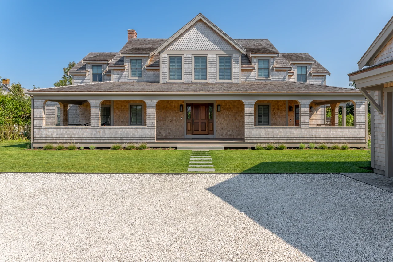 Shingle house with a deep timber porch facing the entry court