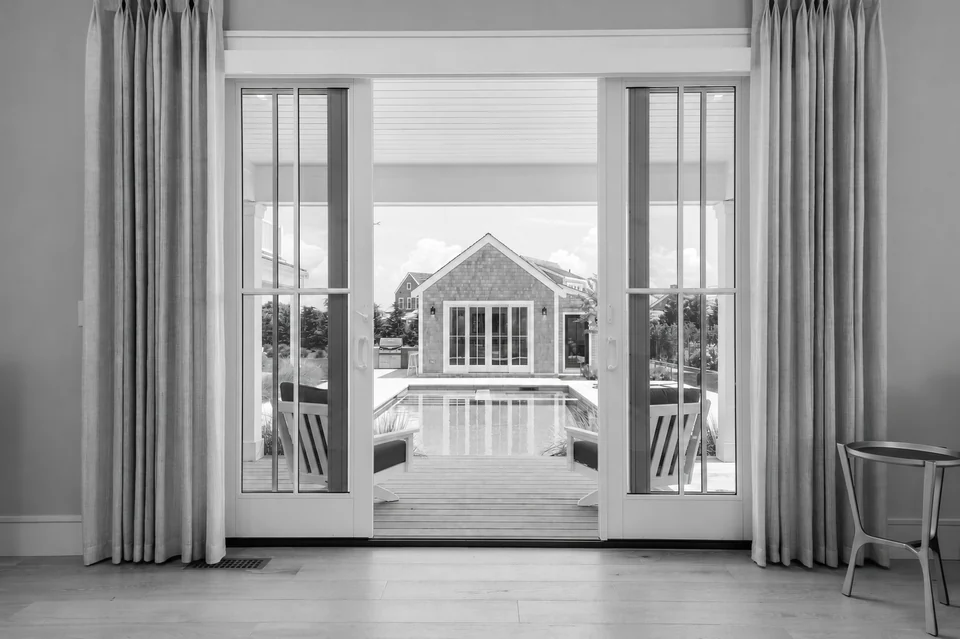 Bedroom doors framing the pool and garden pavilion at Nobadeer
